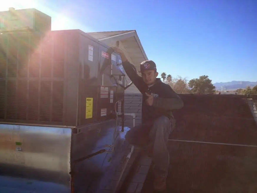 HVAC technician performing AC Tune-Up on a rooftop unit in East Chicago